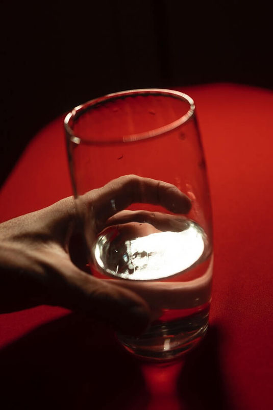 Man tightly holding glass.