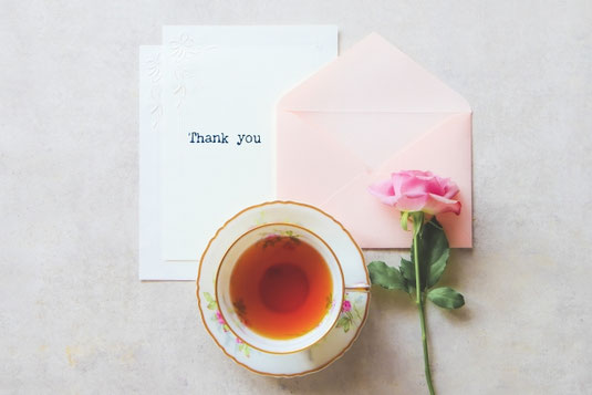 便箋と封筒、一輪のバラの花。紅茶のカップ＆ソーサ。