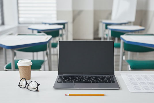 マーブル調のデスクに広げられたタブレット、水色のノート、鉛筆。無造作に置かれたグリーンの葉っぱ。