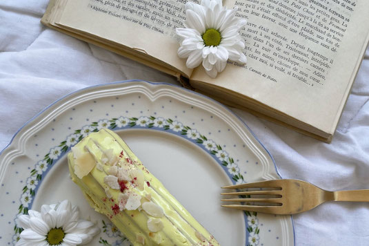 ページが開かれた洋書。そのうえに無造作に置かれた白のバラとクロッカスの花。うさぎのオーナメント。