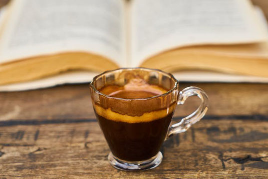ハート形に顔が書かれたクッキー。マグカップのミルクコーヒー。