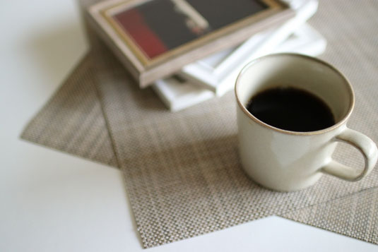 積まれた本。コーヒーの入ったマグカップ。