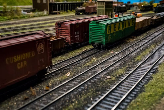 おもちゃの線路の上に置かれたおもちゃの貨物列車。
