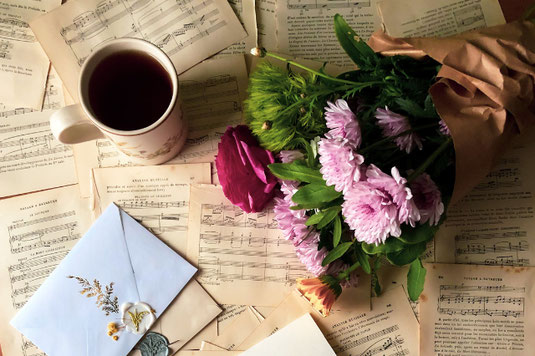 ガラスの瓶に1本ずつ活けられた4本の花。ピンクのダリア。左から背の高さ順に並べられている。