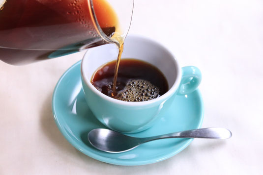 コーヒーサーバーから水色のカップ&ソーサにコーヒーが注がれている。