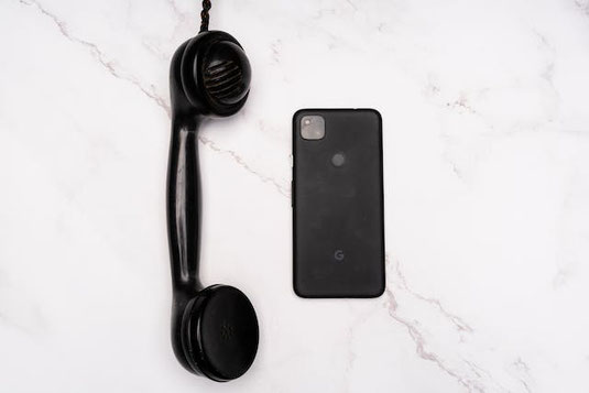 デスクに置かれたノートパソコンとスマホ。いろいろなかたちの吹き出しの付箋。