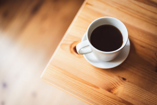 テーブルにコーヒーの入ったカップ&ソーサ。