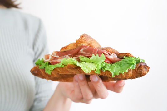 オフィスのデスク。パソコンのキーボードの前に広げられたお弁当箱。鮭弁当。