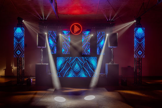 Montaje de sonido e iluminación que incluye una cabina para DJ retroiluminada, altavoces de alta potencia ideales para eventos en interior y exterior y pantalla led dinámica perfecta para una experiencia visual en bodas, fiestas y festivales.