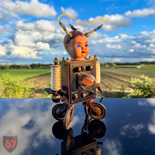 Intuition is an assemblage artwork with historical parts: Doll head, spark plugs, porcelain insulators, devices, glow bulbs 