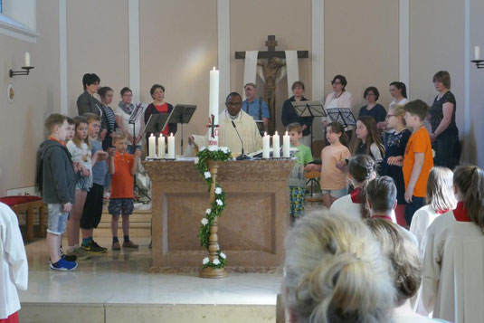 Father Dominik Ekweariri am Altar, zukünftige Erstkommunionkinder und Kreis für junge Musik