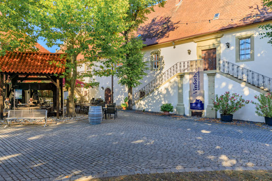Blick auf den gepflasterten Innenhof des Schlosses Krailsheim mit Brunnen.