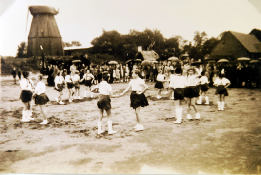 Ein Tanzkreis einer Volkstanzgruppe vor der Mühle in Haßbergen