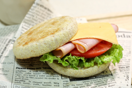 重ねて置かれたリングノートと手帳。そのうえにクッキーのお皿と眼鏡が置かれている。ゴールドのボールペン。観葉植物のリーフ。