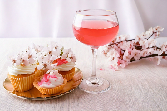 桜の花があしらわれた焼き菓子の皿。いちごのカクテル。桜の小枝。パーティ会場。