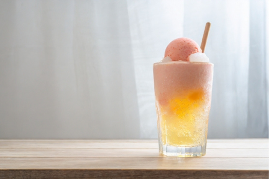 リビングテーブルにクリームソーダのグラス。カーテンがはためいている。