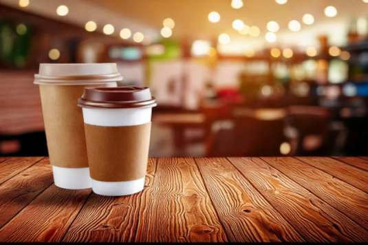カフェのテーブルに置かれたテイクアウトコーヒー。仕事をさぼり中。