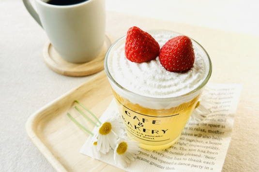 英文資料ペーパーといちごとアイスクリームののったソーダ。カモミールの花。コーヒーの入ったマグカップ。