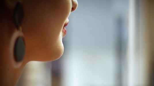 Gros plan de trois-quarts dos sur le visage d’une femme lors du tournage d’une vidéo promotionnelle