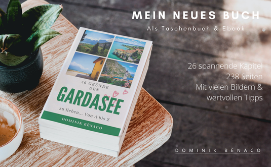 Das neue Buch von Dominik Bènaco liegt auf einem Tisch und trägt den Titel 26 Gründe den Gardasee zu lieben.