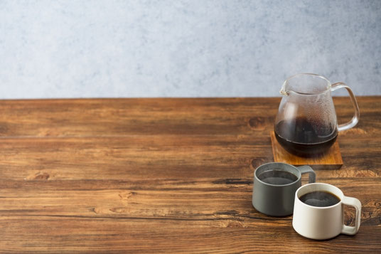 オフィスのデスク。コーヒーサーバーと２つ並んだマグカップ。