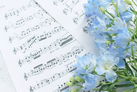 楽譜のうえに無造作に置かれた青色の花たち。