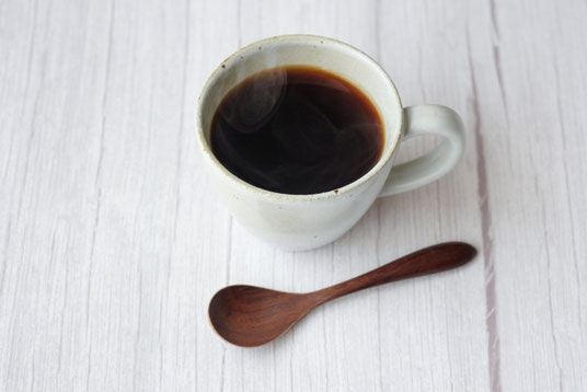 コーヒーの入ったマグカップとコーヒースプーン。