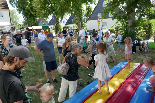 Das Foto zeigt die Menschen auf dem Festplatz vor der Hüpfburg
