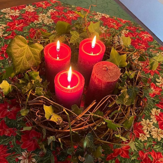 Foto zeigt einen Adventskranz, an dem drei von vier Kerzen entzündet sind.