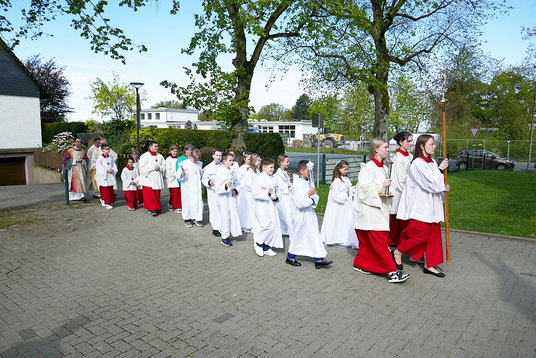 Foto zeigt Kommunionkinder 2024 auf dem Kirchplatz beim Einzug in die Kirche
