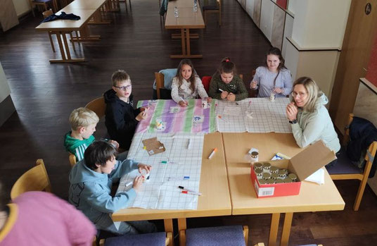 Foto zeigt Kinder am Tisch sitzend, die Kerzen basteln