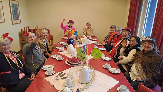 Blick in die Runde der karnevalistisch verkleideten kfd-Damen, die am gedeckten Kaffeetisch sitzen