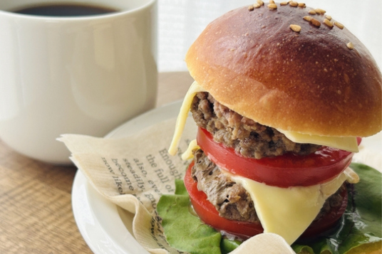 ダブルチーズバーガーのお皿とコーヒーの入ったマグカップ。休憩。