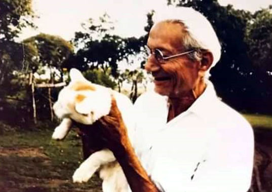 Padri ( Faredoon Navroji Driver ) holding a cat at Meherabad, India