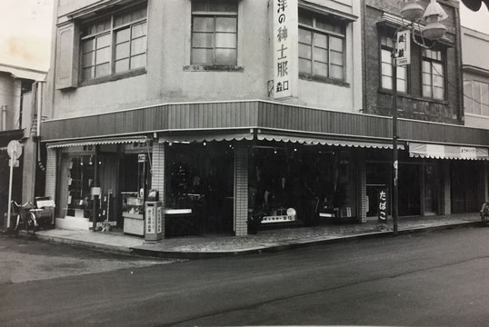 【写真：1950年頃　道路も未舗装時の店舗外観】
