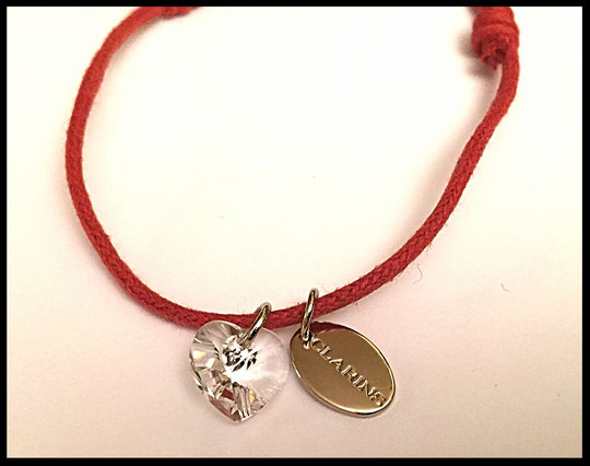 CLARINS - BRACELET CORDONNET AVEC 2 BRELOQUES, DONT UN COEUR EN CRISTAL DE SWAROSVKI