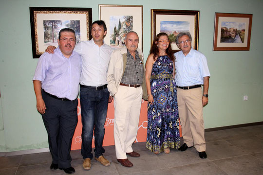Falgas posa frente a sus cuadros con los organizadores de la exposición