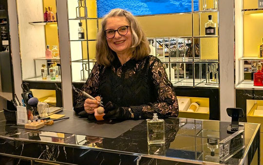 Live-Event-Künstlerin Sigrid Bengel personalisiert Luxusprodukte. Die Gravurkünstlerin im schwarzen Spitzenkleid zeigt live Kalligrafie, Handprägung, Handgravur und Illustration
