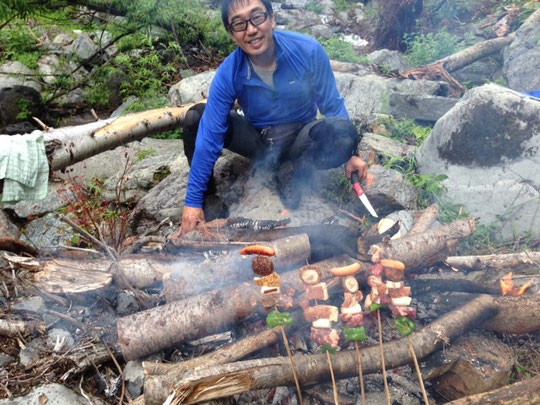 串焼きもたき火で料理します。　撮影:H瀬さん