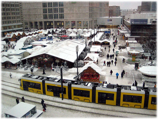 Bilder von der Tram Flexity, wie sie über den verschneiten Alexanderplatz fährt. Die Tram Flexity ähnelt sehr der Comicfigur Homer Simpson. Bilderbuch Berlin. Bilder aus der Geschichte der Hauptstadt.