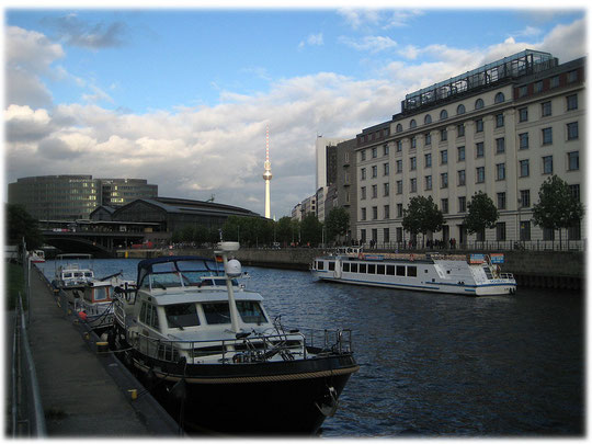 Ein Foto vom Fernsehturm Berlin mit dem Bahnhof Friedrichstraße im Vordergrund. Die Spree ist auf dem Foto ebenfalls zu sehen. Bilder und Fotos aus Berlin und der Berliner Geschichte.