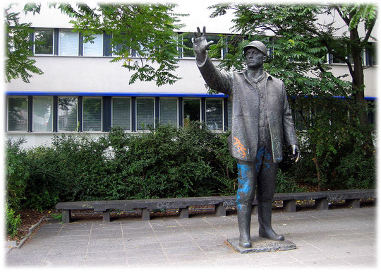 Bild von einem sozialistischen Genossen in Stein und Metall. Auf dem Foto sieht man deutlich, wie der Genosse seine kommunistischen Freunde grüßt.