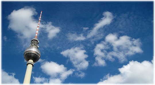 Das Foto zeigt den Berliner Fernsehturm am Alexanderplatz. Der Turm auf dem Bild scheint die Wolken schon zu berühren. Bilder vom Fernsehturm am Alexanderplatz, dem Herzen der DDR und von Ostberlin!