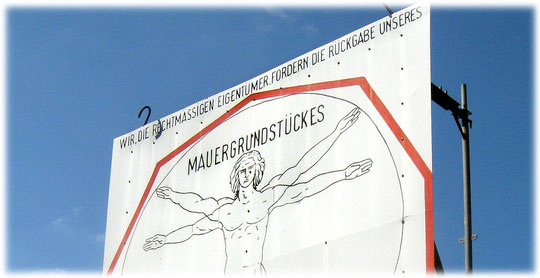 Mit großen Schildern fordern die Enteigneten ihr Mauergrundstück zurück. Der Bau der Mauer in Berlin führte dazu, dass zahlreiche Grundstücksbesitzer enteignet wurden. Bilder der Mauer im Bilderbuch.