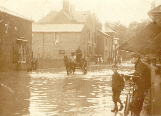 A flood at the Green, showing the low building to the right of the gabled building, later numbers 1087-9