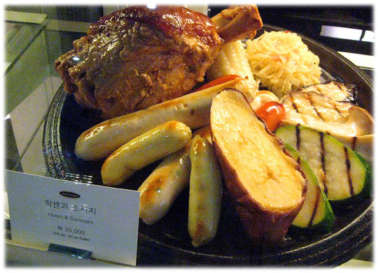 This photo shows German bratwurst, haxen, sauerkraut, and meat. Restaurant at Coex, Gangnam. Foto von Haxen mit Sauerkraut und Bratuwrst und deutschem Bier im Coex Zentrum in Gangnam