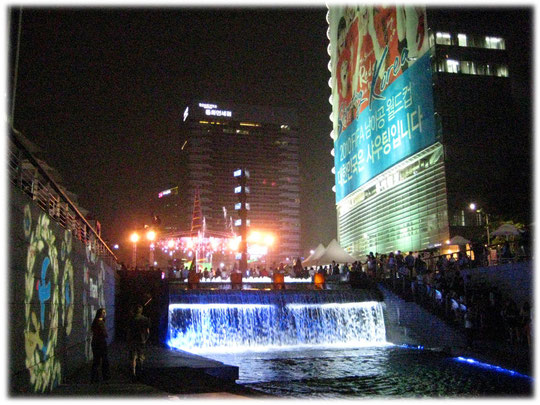 This photo shows Illuminated waterfall at Cheonggyecheon creek at the city center of Seoul. Foto von einem beleuchteten Wasserfall im Zentrum der Stadt Seoul.