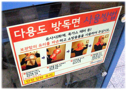 This photo gives an image of how to use the gas masks at the Seoul station. Bild von Gasmasken in einer U-Bahn-Station.