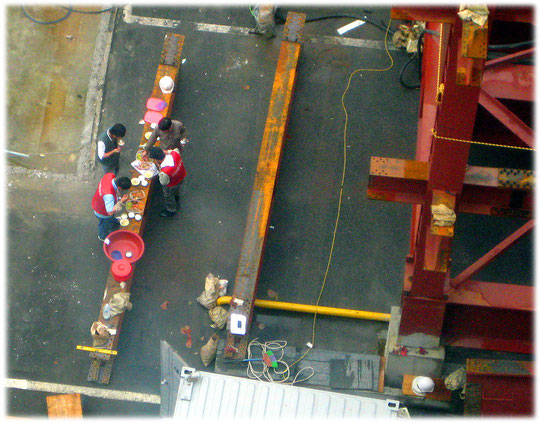 Lovely and interesting picture of workers at a construction site having lunch. Foto von Arbeitern auf einer Baustelle, die gerade ihr Mittagessen gemeinsam essen.