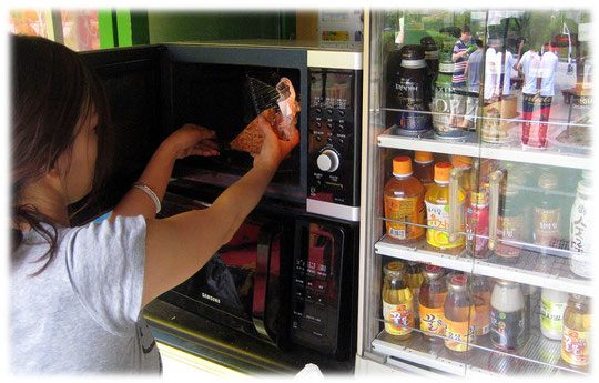 This photo shows a microwave oven at a convenience store. You use it to heat up Korean imbiss dishes and meals. Fotos von einerm Mikrowellengerät in einem koreanischen Kiosk in Seoul. Typisches Essen.